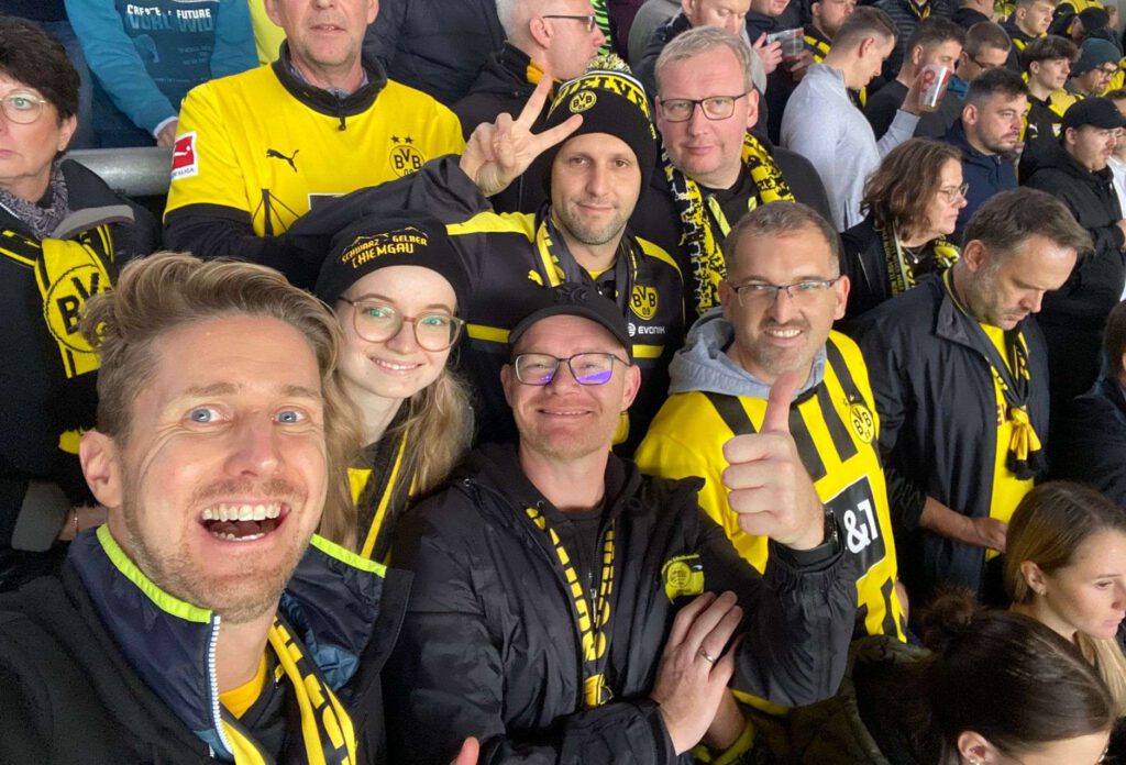 Viele gut gelaunte Fans in BVB-Trikots und Schals drängen sich für ein Selfie im Gästeblock.