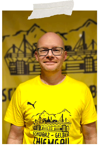 Angeheftetes Foto: Mann mit Brille im gelben Fanclub-T-Shirt vor dem gelben Fanclub-Banner.